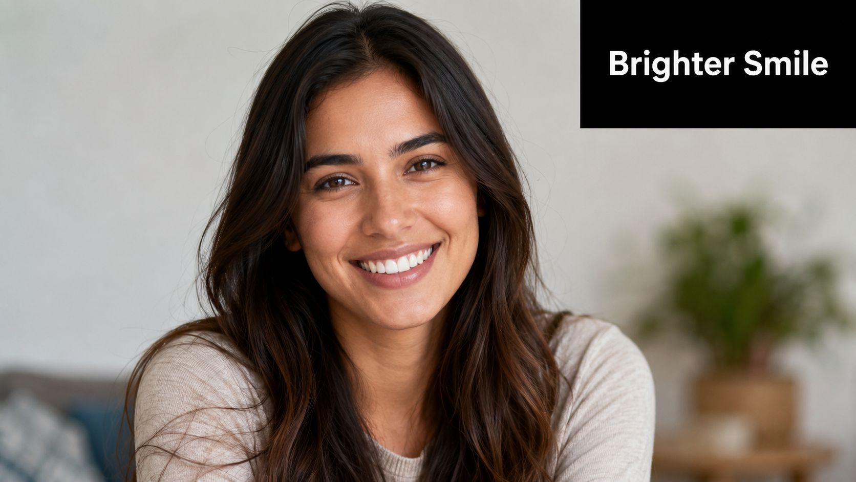 A smiling young woman with healthy white teeth looking at the camera in a bright room.