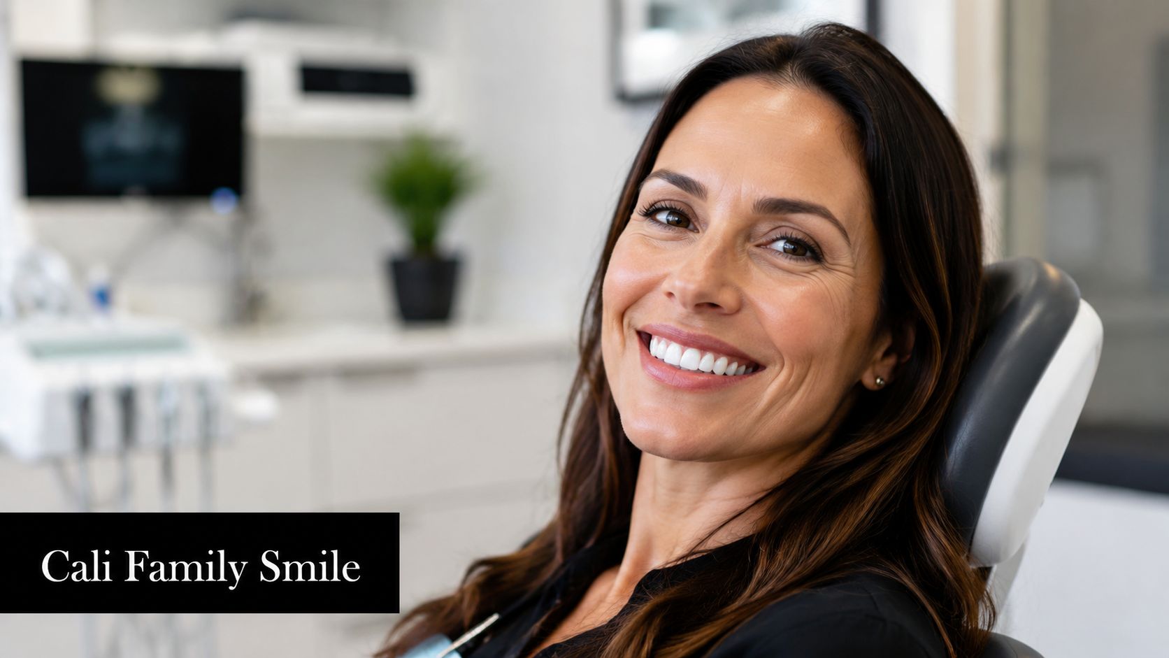 A happy woman with a beautiful smile sitting in a dental chair at a clinic.