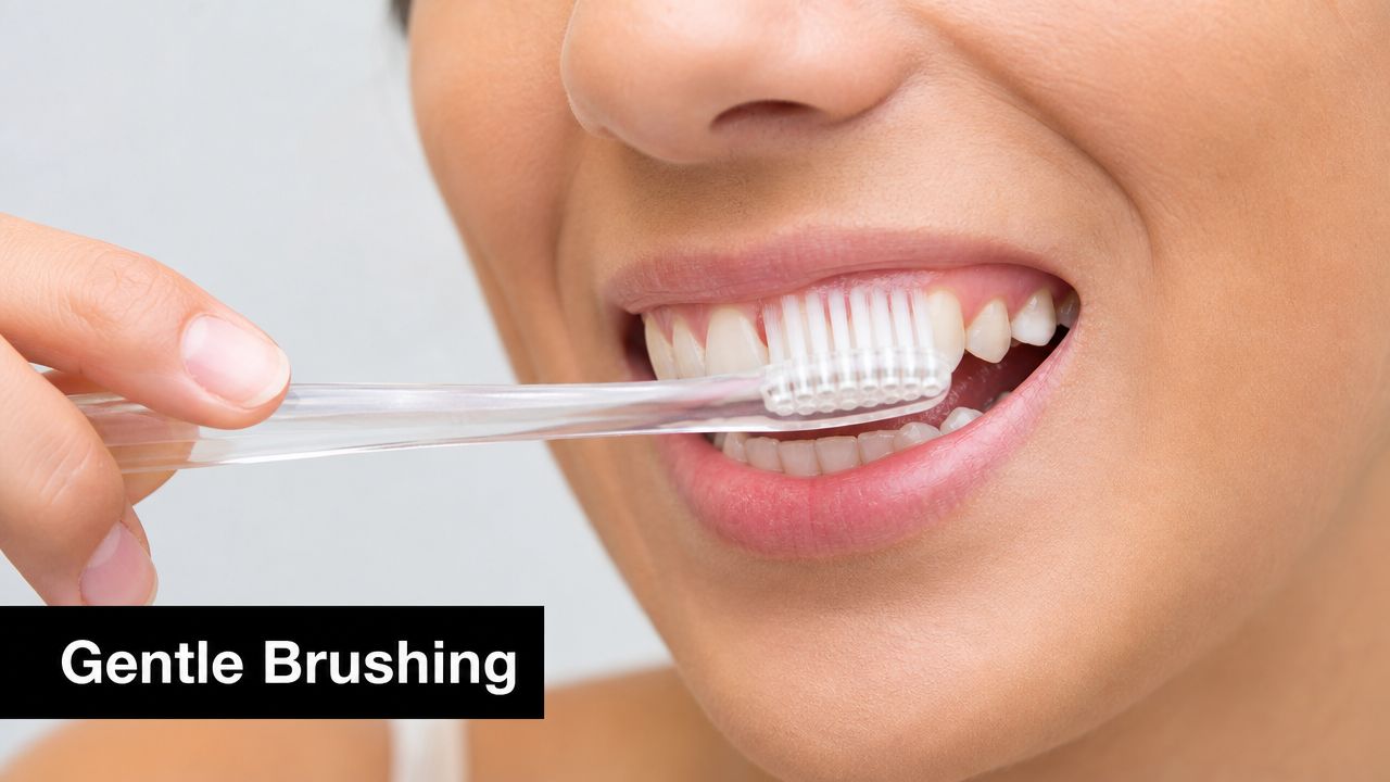 A close-up view of a person using a clear toothbrush for gentle brushing of their teeth